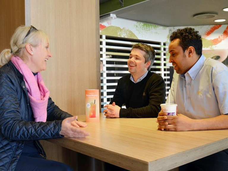 Two men and a woman sitting at a table.