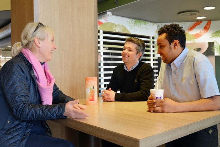 Two men and a woman sitting at a table.