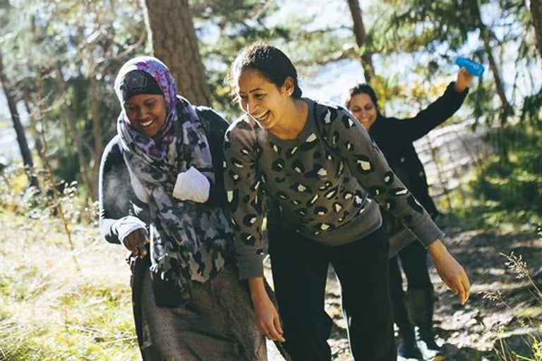 A group of people walking through a forest.