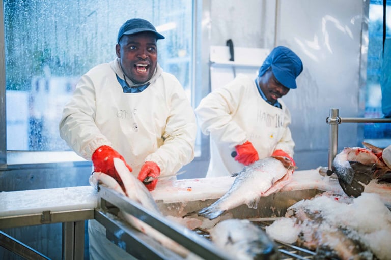 Et par menn som står ved siden av hverandre på et kjøkken.